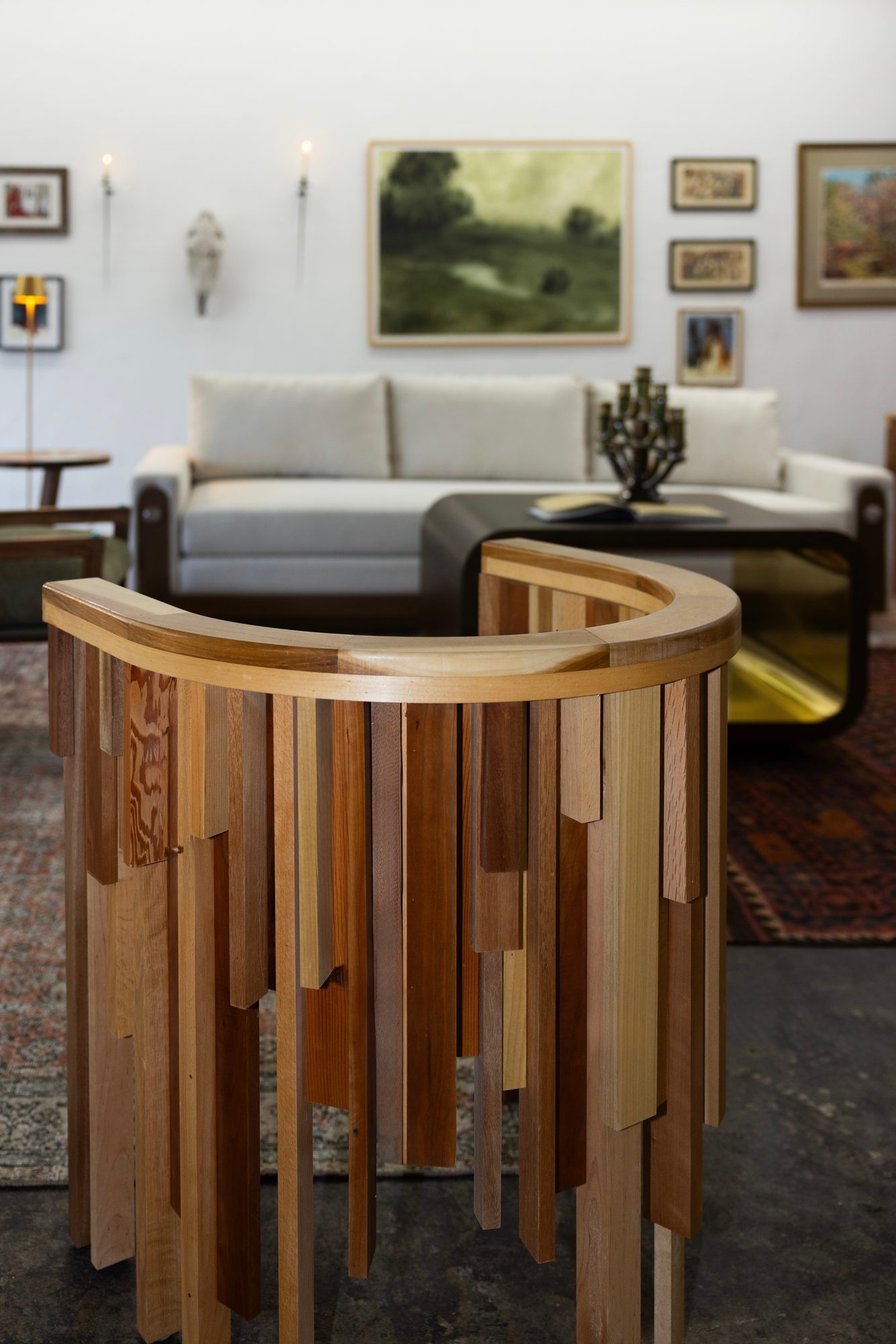 Wood-slat barrel chair in front of a cream sofa